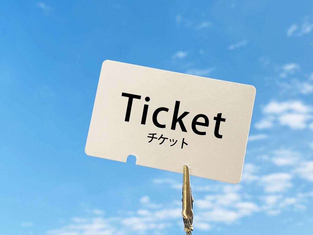 ticket(チケット)と書かれた紙とクリップ、青空