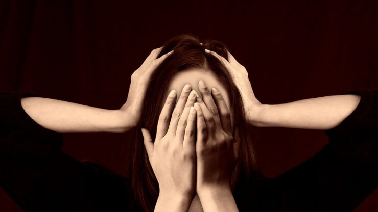 神経の損傷
女性が顔に両手を当て隠している、別の手が頭も両手でかかえてる