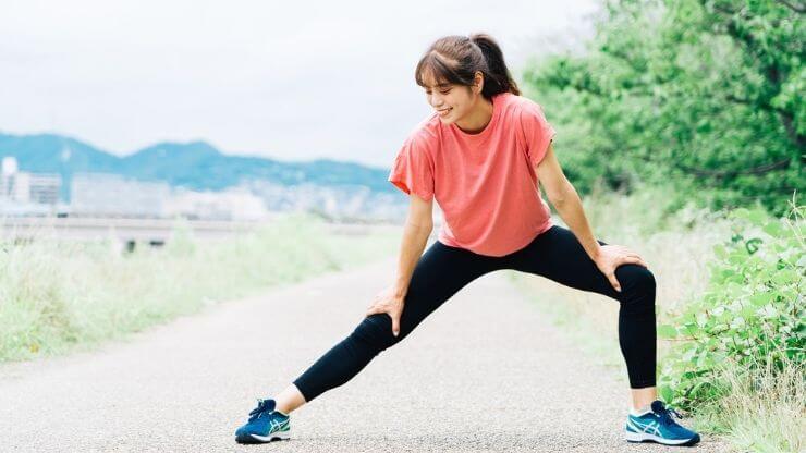 スポーツウェアを着てストレッチをする女性の写真