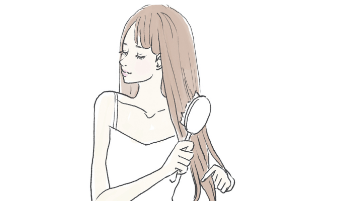 髪のブラッシングをする女性