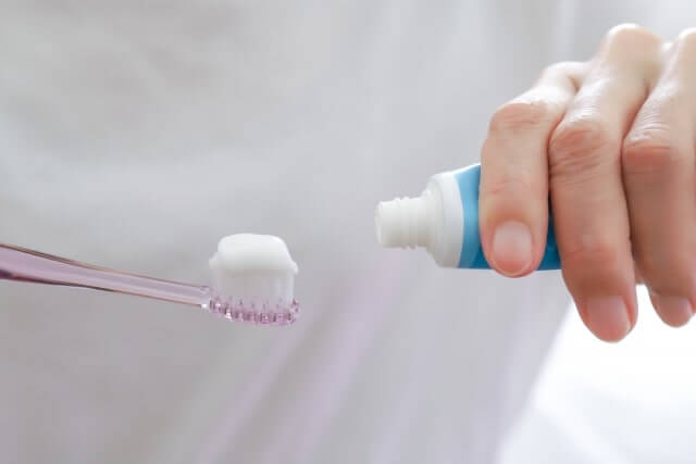 歯ブラシに歯磨き粉をつける女性