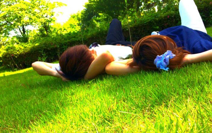 芝生で寝転ぶカップル